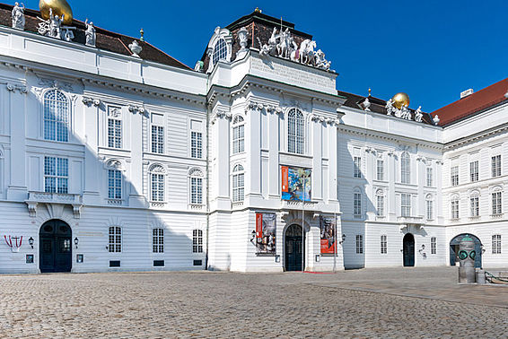 Weißes Gebäude mit Statuen am Dach