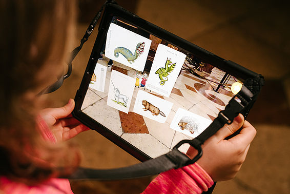 Ein Mädchen betrachtet ein Tablet im Prunksaal