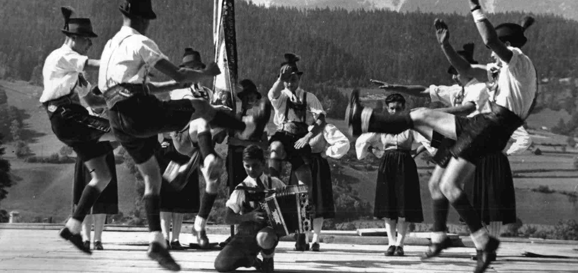 Gruppe von Schuhplattlern vor Berglandschaft