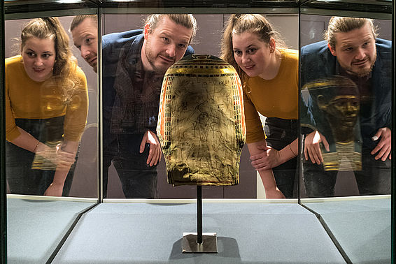 Ein Mann und eine Frau bestaunen eine Vitrine im Papyrusmuseum