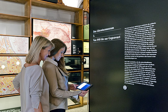 Zwei Menschen in Museumsraum mit Bücherregalen