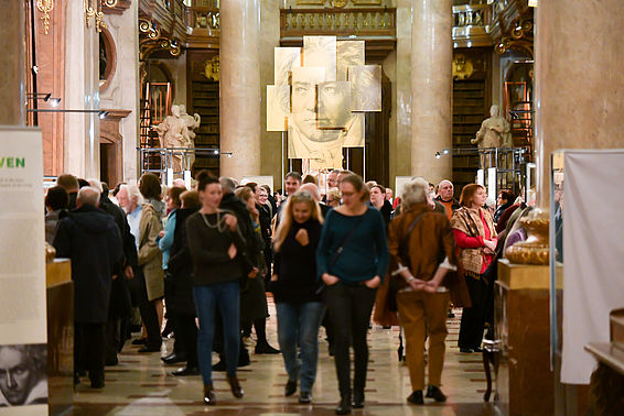 Gut besuchter Prunksaal mit goldenem Porträt von Ludwig van Beethoven im Hintergrund 