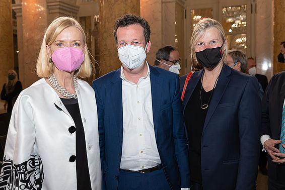 Zwei Frauen und ein Mann in eleganter Kleidung