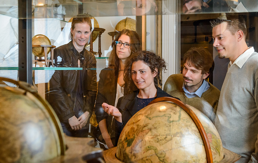 3 Frauen und 2 Männer bestaunen Vitrine im Globenmuseum