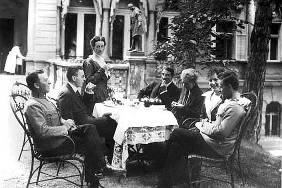 Ludwig Wittgenstein sitzt mit seiner Familie an einem Tisch in einem Garten bei Kaffee und Kuchen, schwarz-weiß