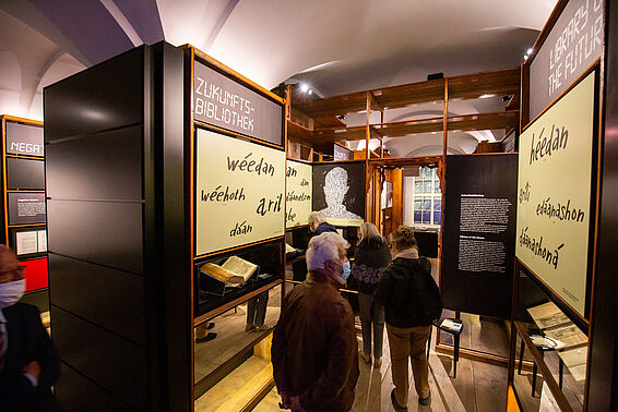 BesucherInnen im Literaturmuseum neben Bücherregalen mit großen Schautafeln