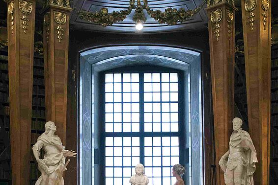 Foto von Frau in weißem Kleid in Marmorsaal vor einem großen Fenster