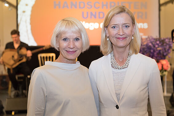 2 weiß gekleidete Frauen vor oanger Leinwand, Gitarrist im Hintergrund