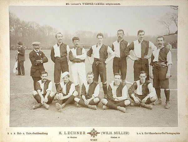 Schwarz-weißes Foto von Fußball-Mannschaft und ein Mann Schnauzer posieren auf Fußballfeld.
