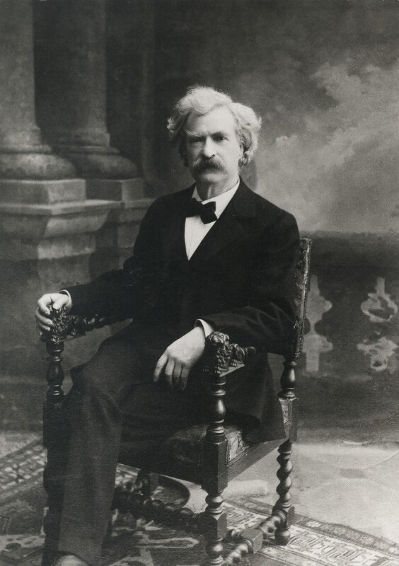 Schwarz-weißes Foto von sitzendem Mann mit Anzug und weißen Haaren.