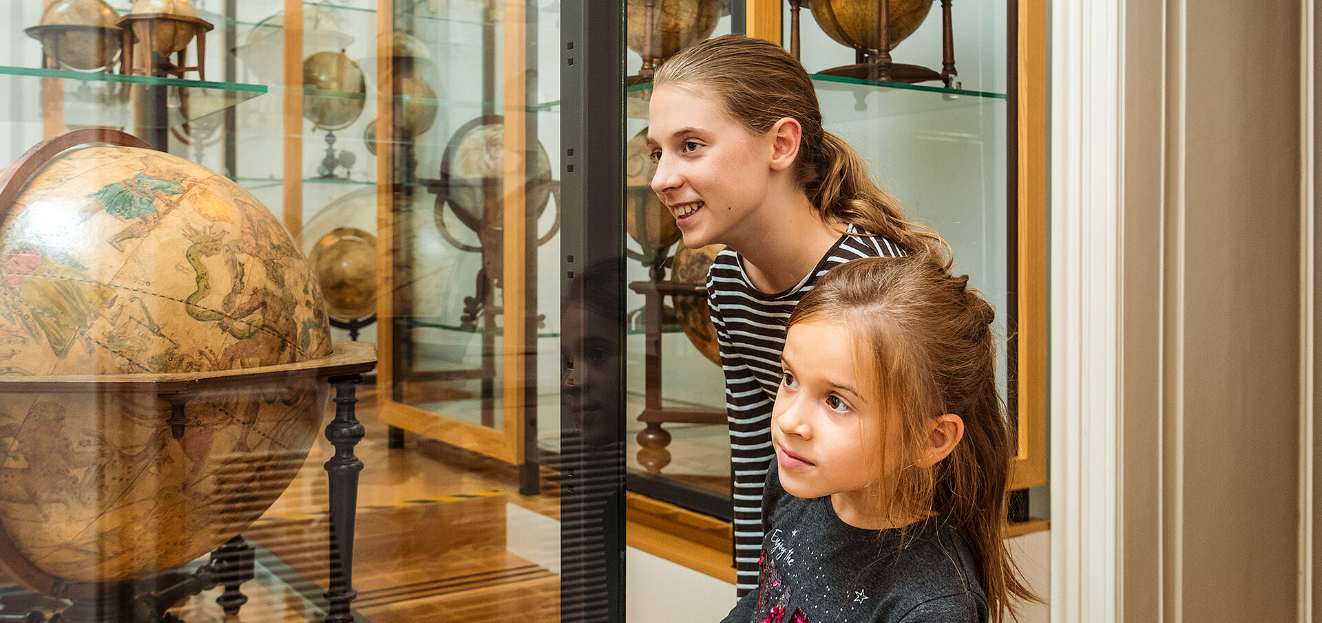  Zwei Mädchen bestaunen einen Himmelsglobus im Globenmuseum