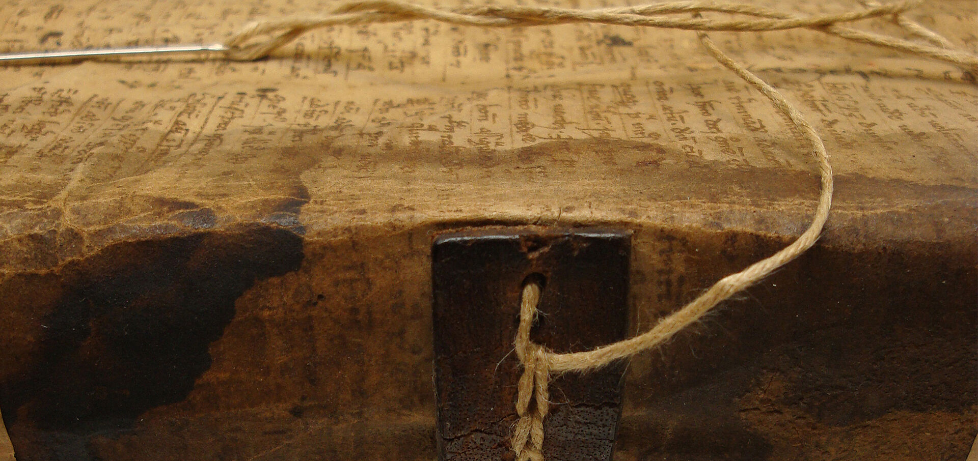 Antiker Buchrücken mit Faden und Nadel