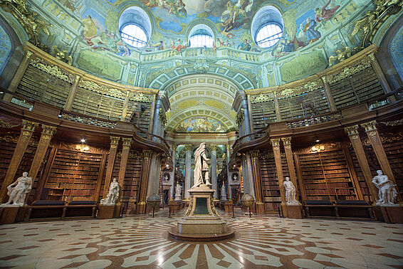 Marmorsaal mit Bücherregalen und Deckenfresko, ohne Menschen, mit Statue von Karl VI. im Zentrum
