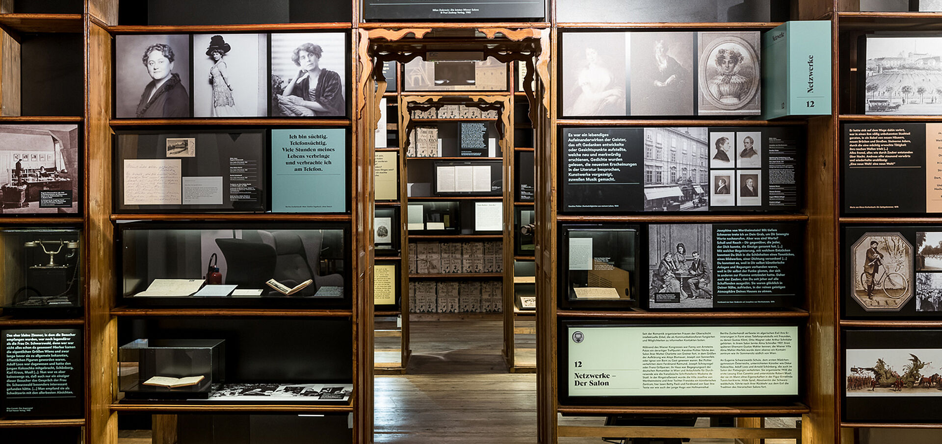 Foto eines Museumsraums mit Bücherregalen, in denen Fotos hängen