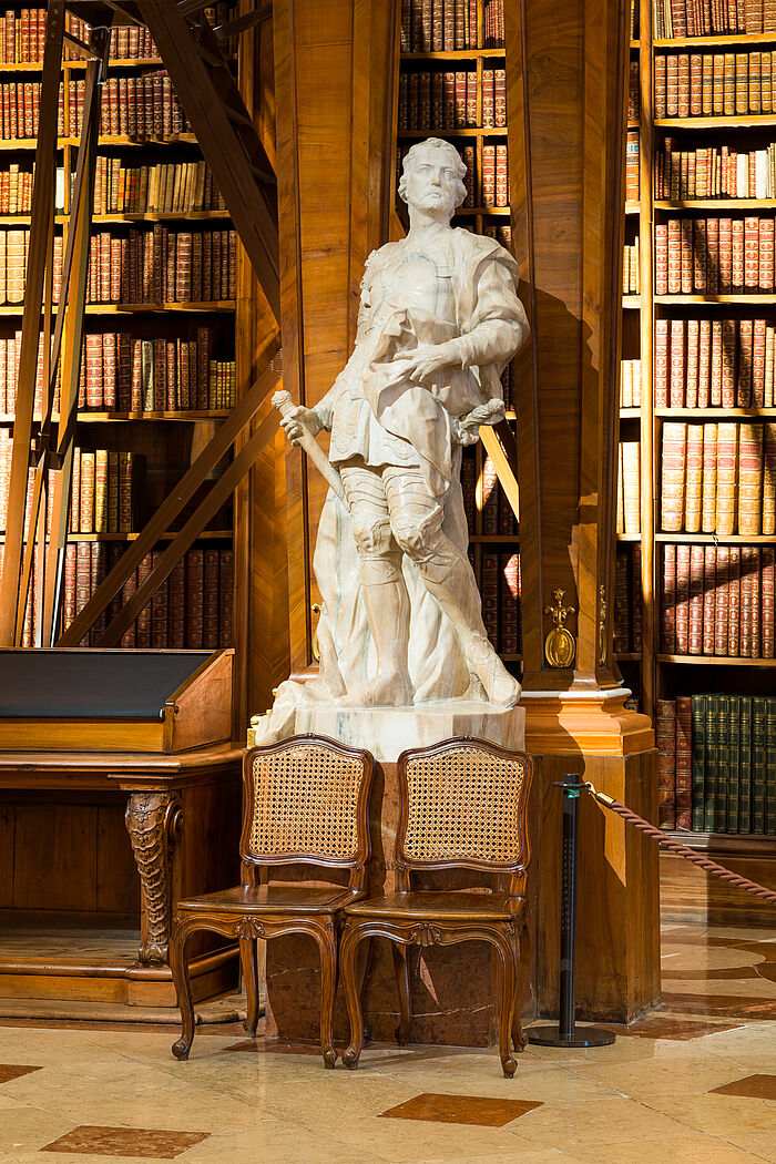 Statue vor Bücherregalen in Marmorsaal.