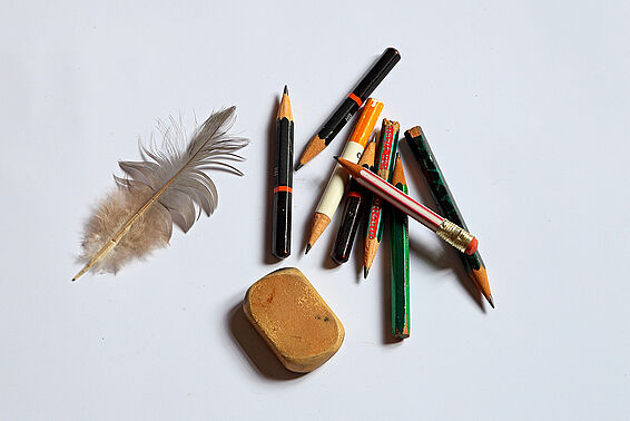 Foto von einer Feder und vielen Bleistiftstummeln