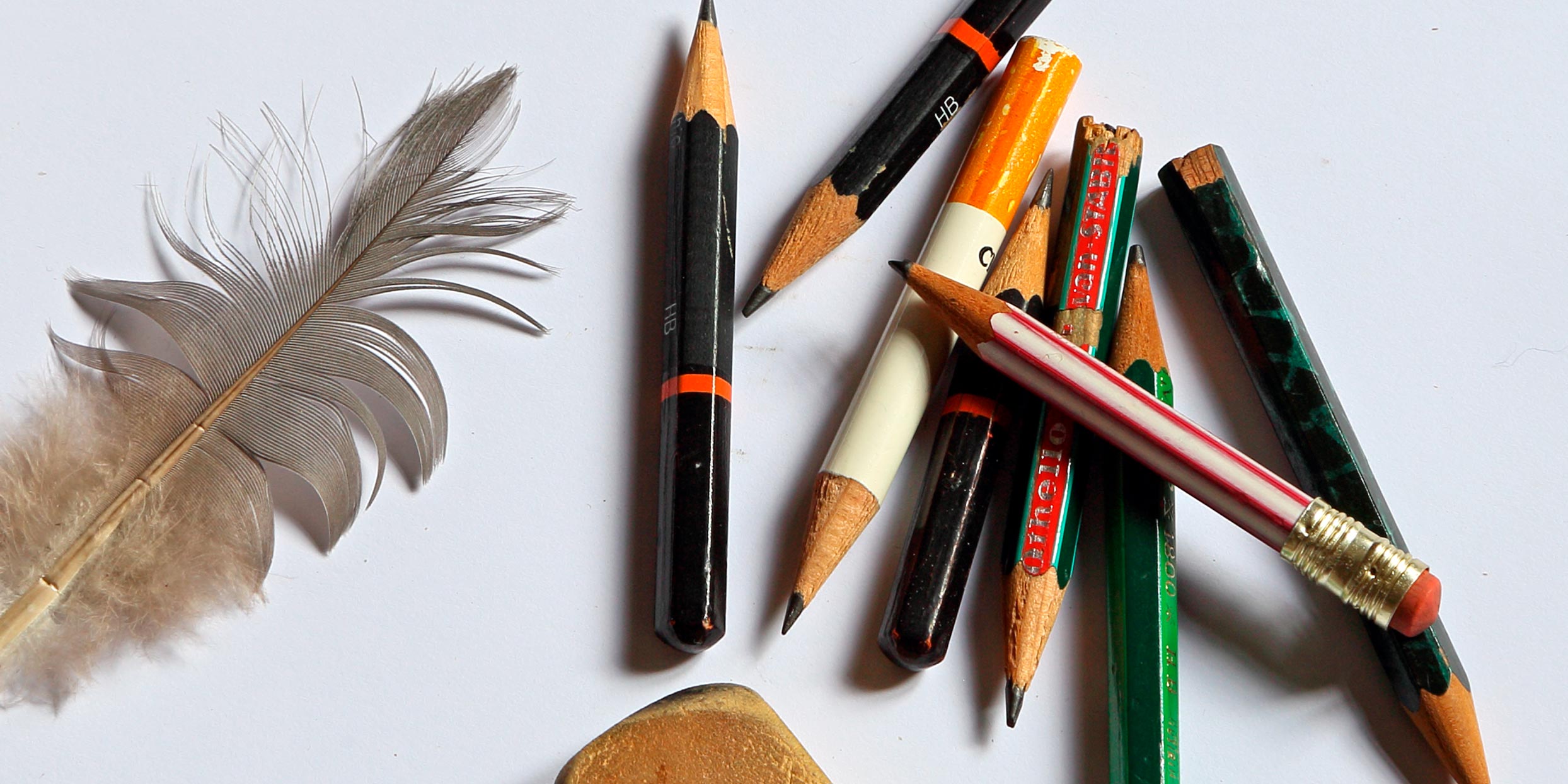 Foto von einer Feder und vielen Bleistiftstummeln