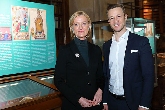 Ein Mann im Anzug und eine Frau stehen in einem Museum.