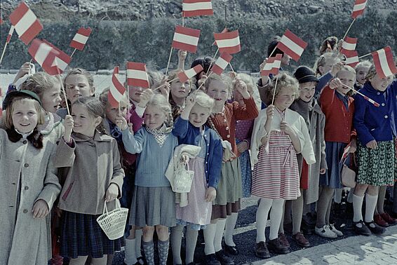 Eine Gruppe Mädchen schwingt Österreich-Flaggen