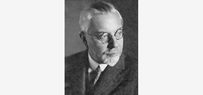 Porträtfoto, Mann mit runder Brille blickt zur Seite, schwarz-weiß