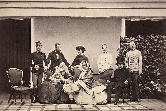 Große Familie in eleganter Kleidung posiert vor einem Haus in zwei Reihen, Foto, schwarz-weiß