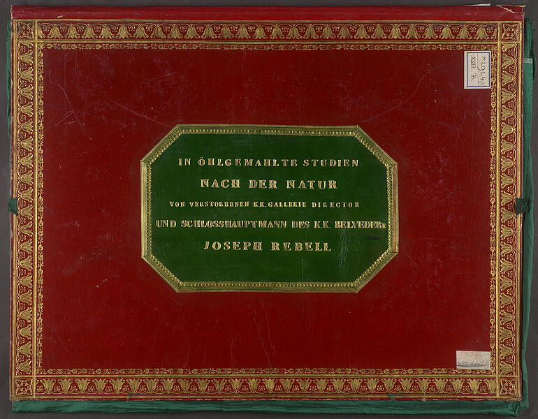 Deckel einer roten, prächtig goldverzierten Mappe, darauf ein grünes Etikett, auf dem in Gold steht: "IN ÖHLGEMAHLTE STUDIEN NACH DER NATUR VON VERSTORBENEN K.K. GALLERIE DIRECTOR UND SCHLOSSHAUPTMANN DES K.K. BELVEDERE JOSEPH REBELL" 