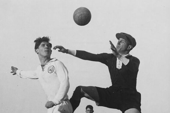 Tormann und Torjäger springen nach dem Ball