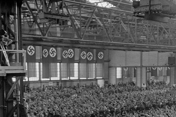Volle Halle mit Hitlerfahnen, Menschen machen den Hitlergruß
