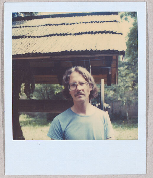 Polaroid-Foto von Mann draußen vor Brunnendach