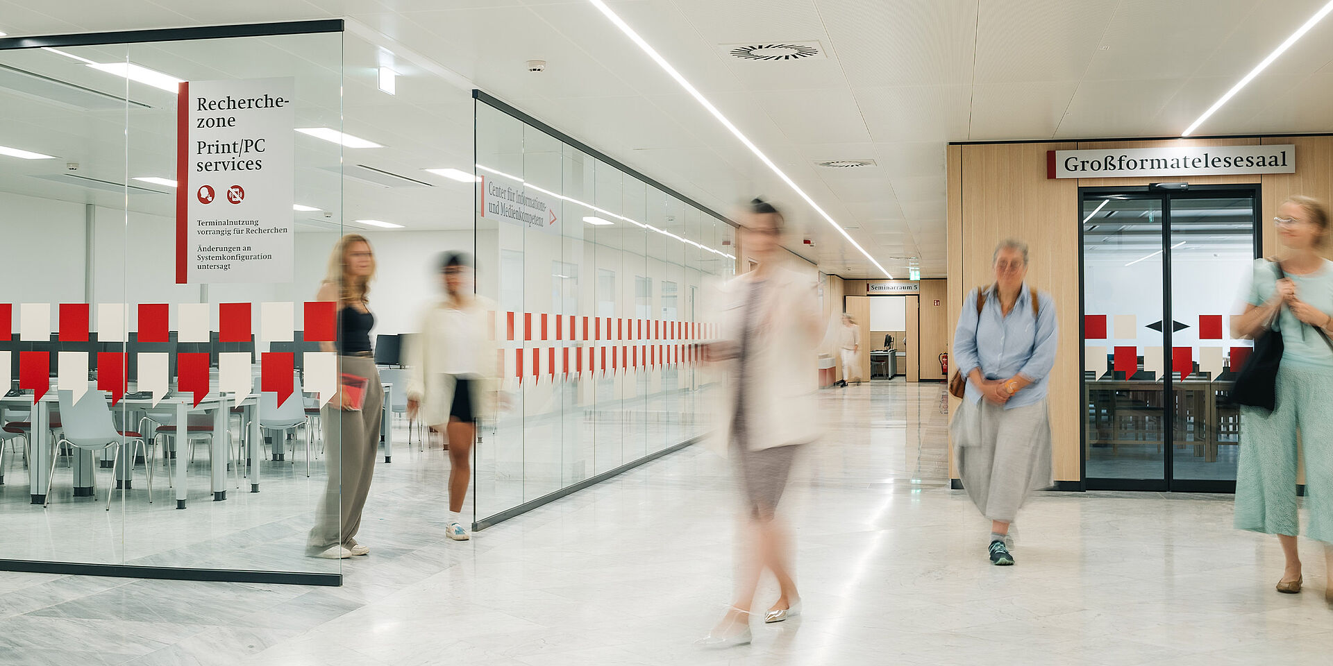 Menschen bewegen sich in einem modernen Raum mit Glastüren