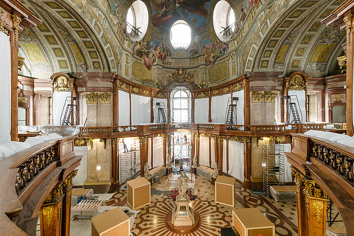 Großer Marmorsaal voller verhangener Bücherregale.