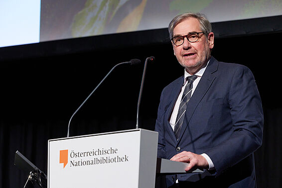 Mann mit Brille an Rednerpult