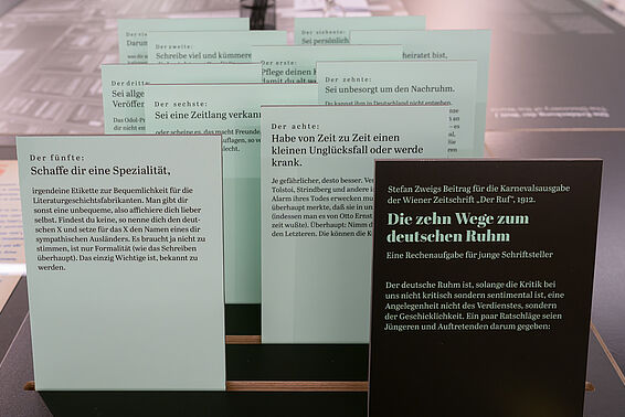 Kleine Holztafeln in Schwarz und Türkis mit Textstellen.