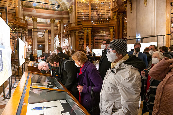 Personen in einer Ausstellung in einem Marmorsaal