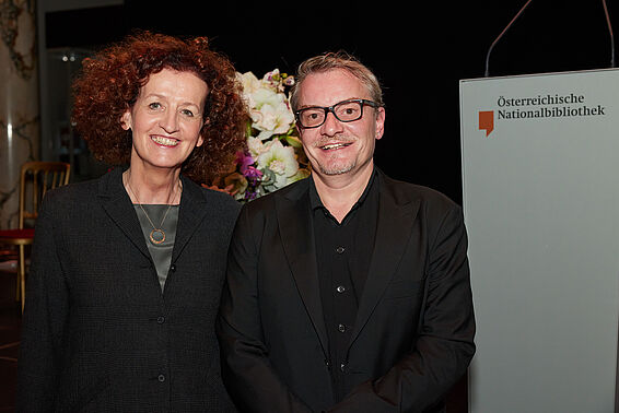 Ein Mann und eine Frau posieren lächelnd.