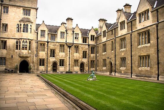 Außenansicht des Trinity College, altes burgähnliches Gebäude mit grüner Wiese davor