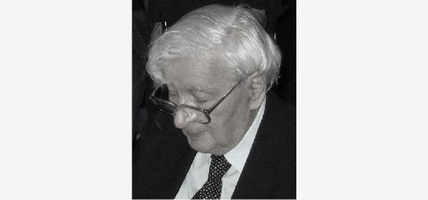 Mann mit Brille und Anzug, Blick nach unten links, schwarz-weiß