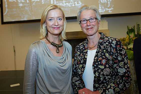 2 blonde Frauen vor einer Leinwand