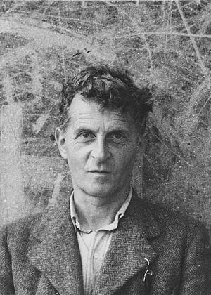 Schwarzweiß-Portrait von Ludwig Wittgenstein vor einer bemalten Mauer