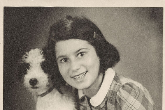 Girl in plaid dress posing with a dog