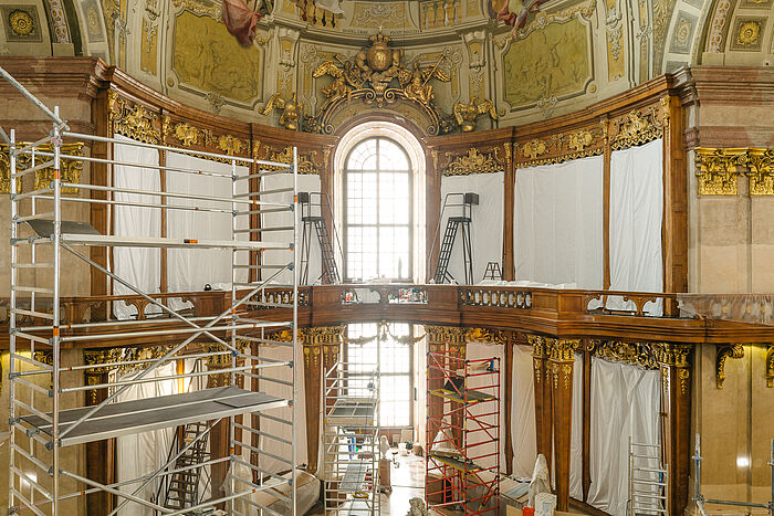 Marmorsaal mit verhangenen Bücherregalen und Baugerüsten.