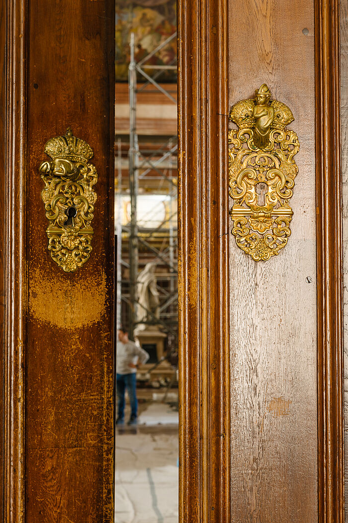 Alte Türklinke, unter der das Holz abgewetzt ist.