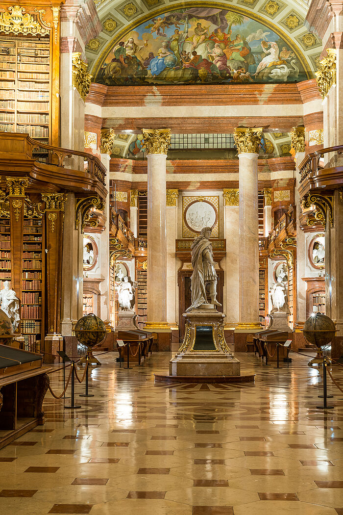 Marmorsaal mit Statuen, Bücherregalen und Deckenfresken.