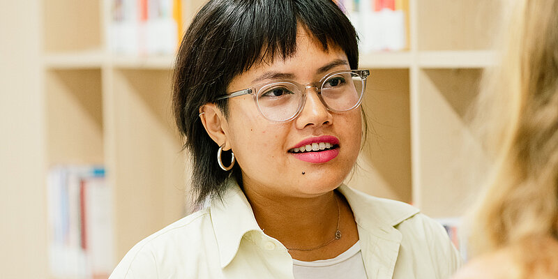 Person mit schwarzen Haaren und Brille