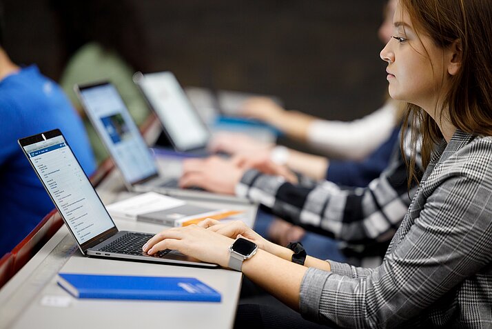 Eine Frau arbeitet auf einem Laptop.