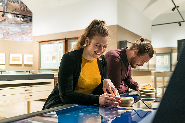 Two people are looking at the media table in the Papyrus Museum.
