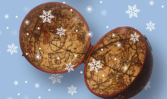 Foto von aufgeklapptem, altem Globus und Schneeflocken