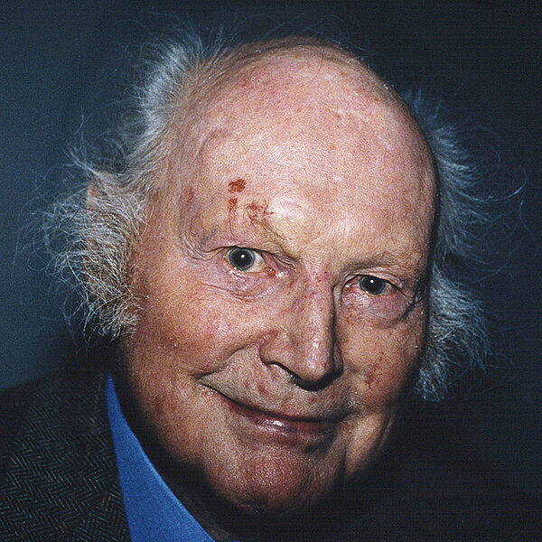Foto von älterem Mann, der in die Kamera schaut.