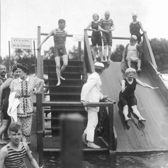 Menschen in lustigen Badeanzügen auf einer Wasserrutsche