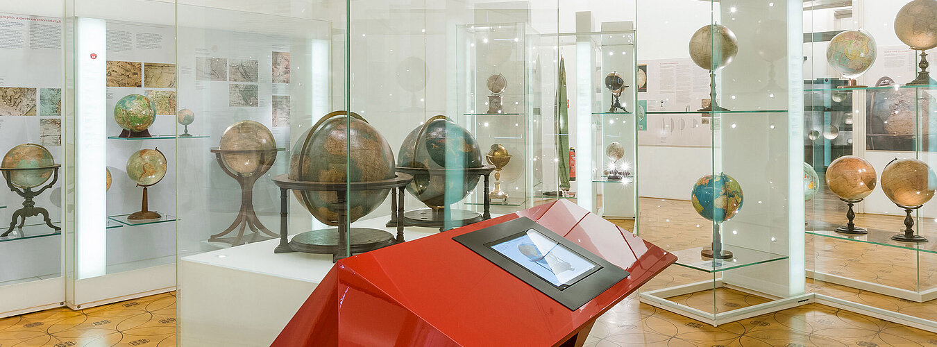 Globen in Vitrinen in einem Ausstellungsraum